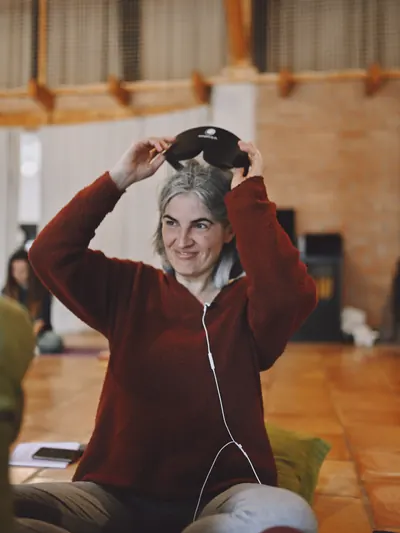 Alumna sonriendo mientras se quita el antifaz al terminar la práctica