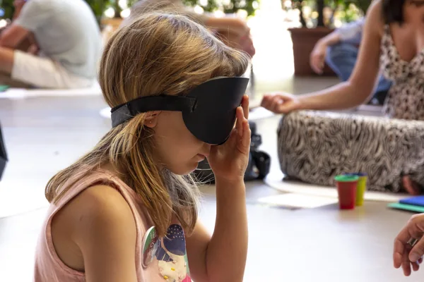 Niña ajustándose el antifaz antes de empezar a practicar