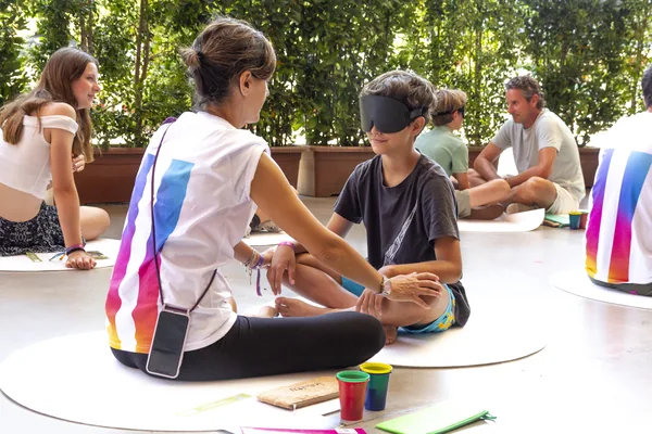 Varias parejas de niño y acompañante practicando con antifaz al aire libre